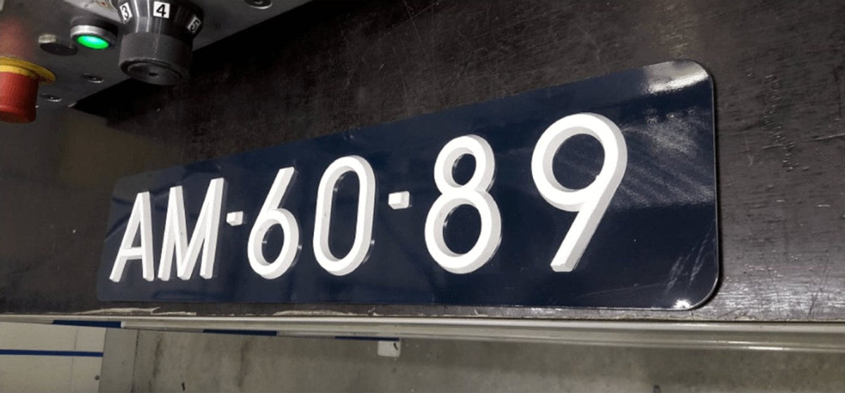 Donkerblauwe oldtimerplaat met opgelegde witte letters, net van de pers