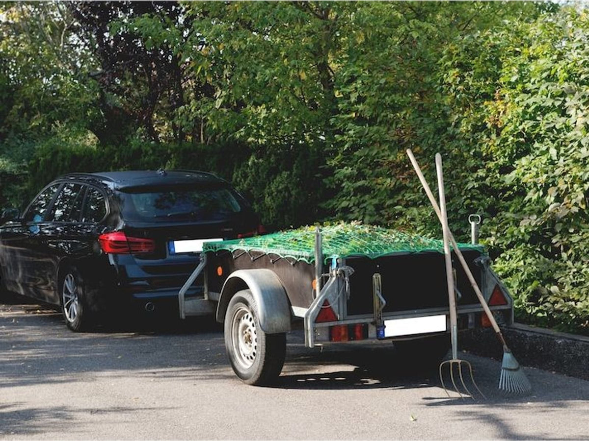 Aanhangernet over een geladen aanhanger achter een auto